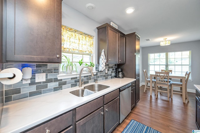 kitchen featuring hardwood / wood-style floors, sink, tasteful backsplash, stainless steel dishwasher, and dark brown cabinets