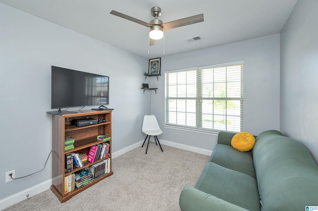 living area featuring light carpet and ceiling fan