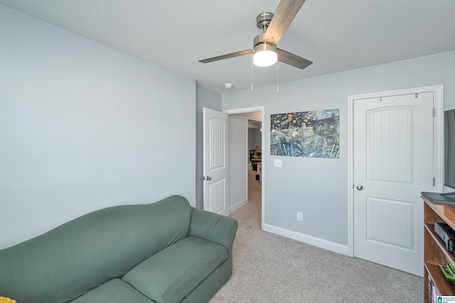 living area with light carpet and ceiling fan