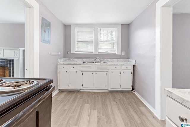 kitchen featuring electric panel, sink, electric range, white cabinetry, and light hardwood / wood-style flooring