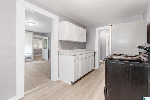 kitchen featuring light hardwood / wood-style floors, white cabinetry, and electric range