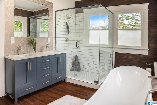 bathroom with backsplash, wood-type flooring, vanity, and plus walk in shower