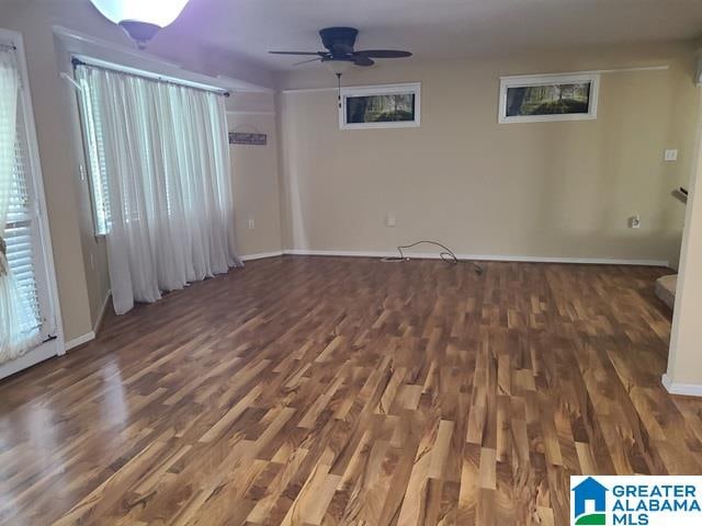 empty room with ceiling fan and dark hardwood / wood-style flooring