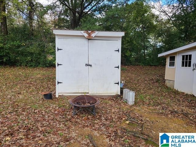 view of outbuilding with an outdoor fire pit