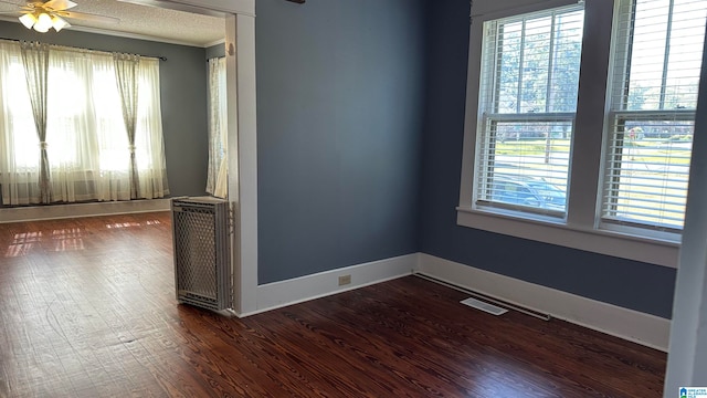 unfurnished room with dark wood-type flooring, ceiling fan, and plenty of natural light