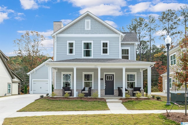 view of front of property with a porch, a garage, and a front lawn