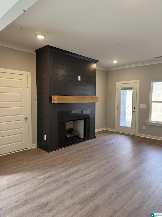 unfurnished living room with a fireplace, light wood-type flooring, and ornamental molding