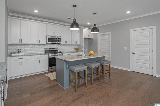 kitchen with white cabinetry, sink, dark hardwood / wood-style flooring, an island with sink, and appliances with stainless steel finishes