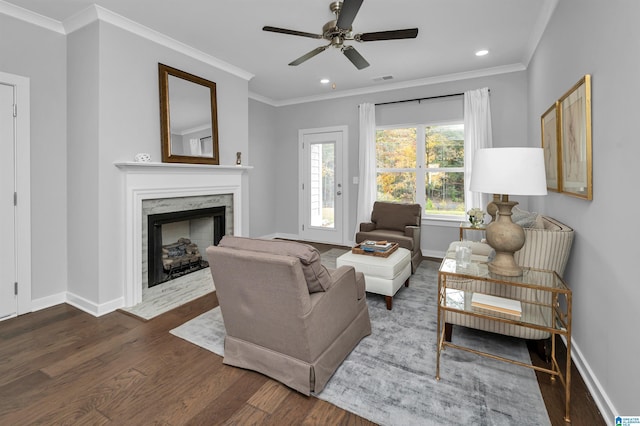 living room with crown molding, a fireplace, ceiling fan, and dark hardwood / wood-style floors