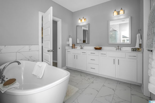 bathroom featuring a bath, vanity, and tile walls