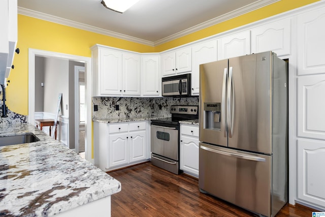 kitchen with stainless steel appliances, ornamental molding, light stone countertops, white cabinets, and dark wood-type flooring