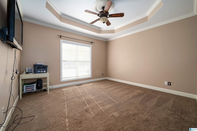 carpeted spare room with a tray ceiling, ceiling fan, and crown molding