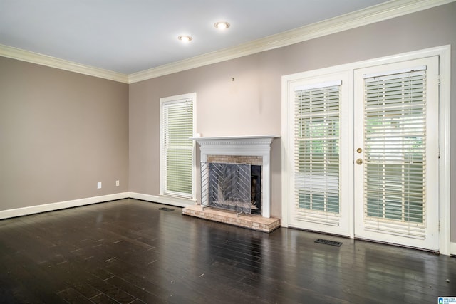 unfurnished living room with dark wood-type flooring, ornamental molding, and a brick fireplace