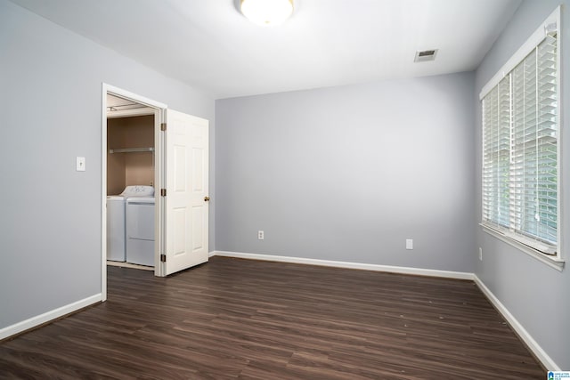 unfurnished bedroom featuring dark hardwood / wood-style flooring and washer and clothes dryer