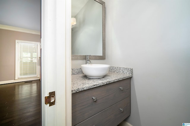 bathroom featuring hardwood / wood-style floors, vanity, and crown molding