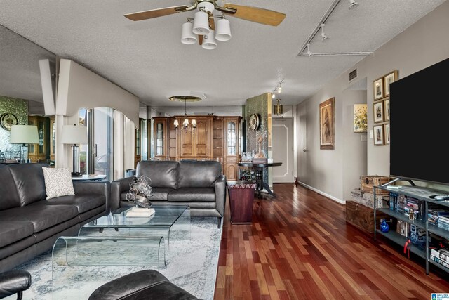 living room with track lighting, dark hardwood / wood-style flooring, and a textured ceiling