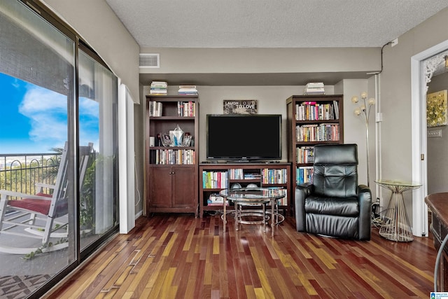 living area featuring a textured ceiling, plenty of natural light, and dark hardwood / wood-style floors