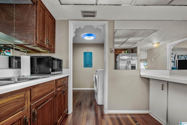 kitchen featuring stainless steel refrigerator with ice dispenser, washing machine and dryer, and dark hardwood / wood-style flooring