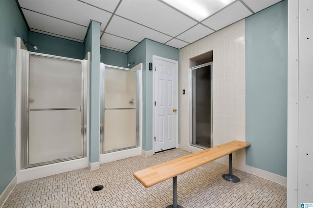 bathroom featuring tile patterned floors, a drop ceiling, and a shower with door