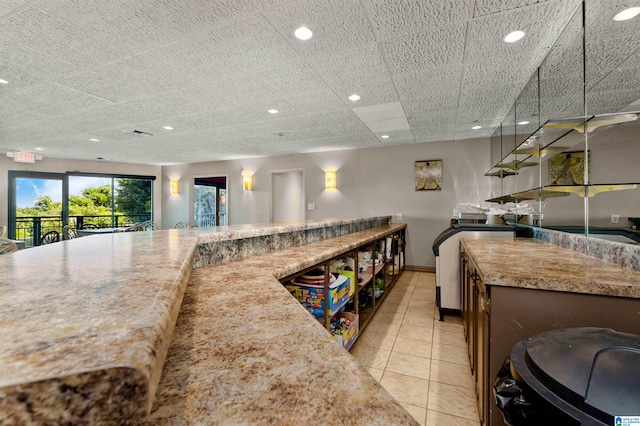 kitchen with light tile patterned floors and light stone countertops