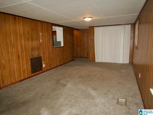 basement featuring wooden walls and light carpet