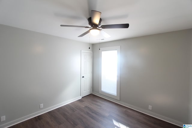 empty room with dark wood-type flooring and ceiling fan