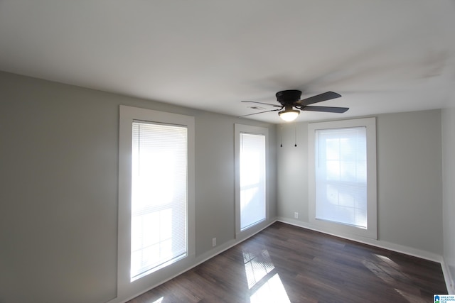 unfurnished room with dark hardwood / wood-style flooring and ceiling fan