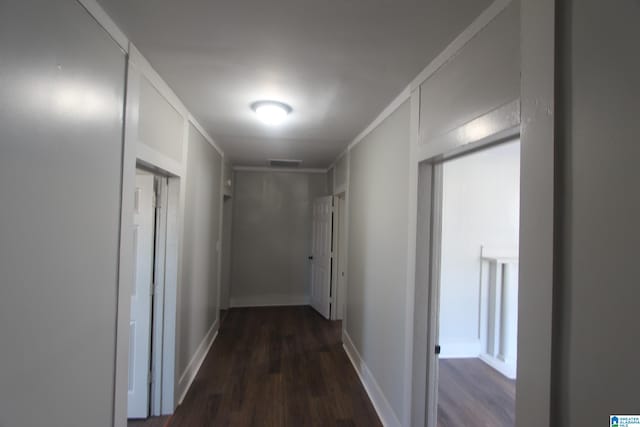 hallway with dark hardwood / wood-style floors and ornamental molding