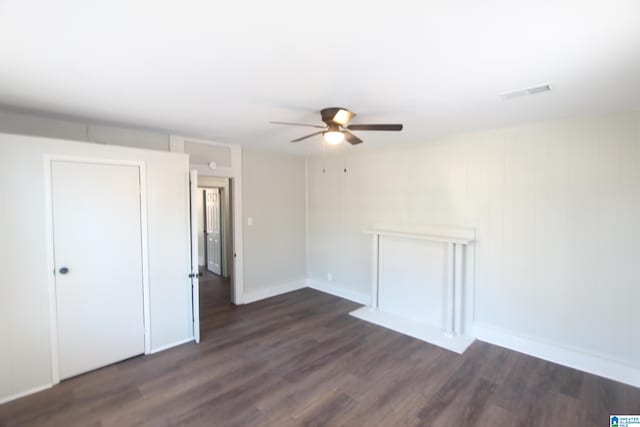 spare room featuring dark wood-type flooring and ceiling fan