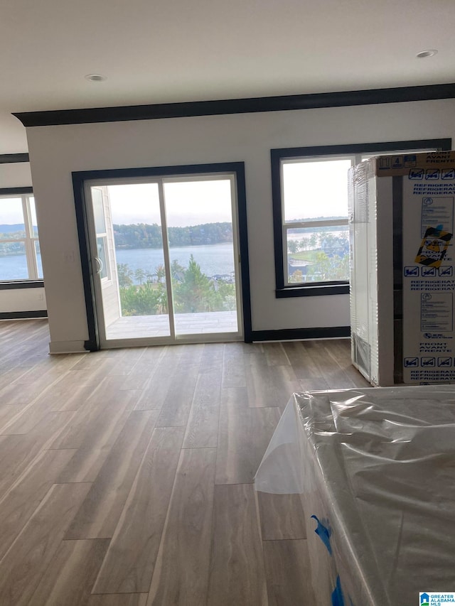 unfurnished living room with a water view and hardwood / wood-style flooring