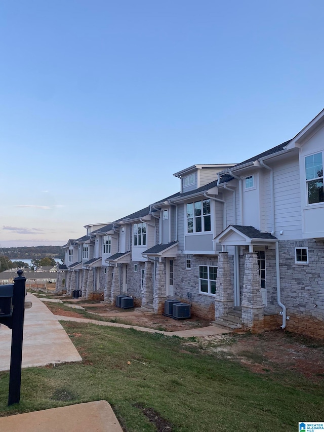 view of front of property with central AC, a yard, and a patio area