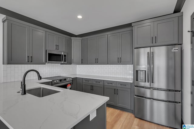 1174 Ranch Marina Rd, Pell City, AL 35128 - kitchen with stainless steel appliances, a sink, light stone counters, gray cabinets, and a peninsula