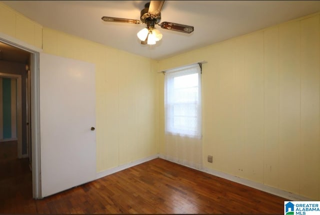 unfurnished room with dark wood-type flooring and ceiling fan