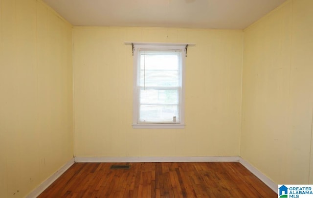 empty room with dark hardwood / wood-style flooring