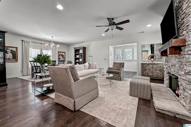 living room featuring dark wood-type flooring, a stone fireplace, and plenty of natural light