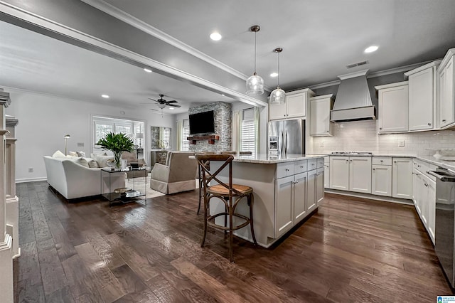 kitchen featuring stainless steel appliances, custom exhaust hood, a kitchen island, and dark hardwood / wood-style flooring