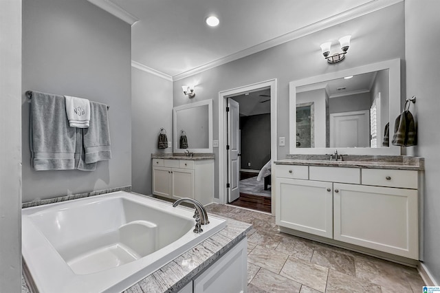 bathroom featuring a washtub, vanity, and ornamental molding