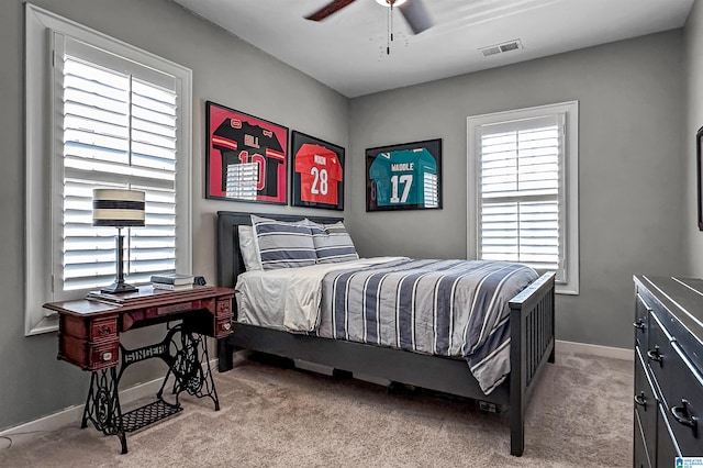 bedroom featuring multiple windows, light carpet, and ceiling fan