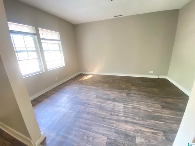 unfurnished room with dark hardwood / wood-style flooring