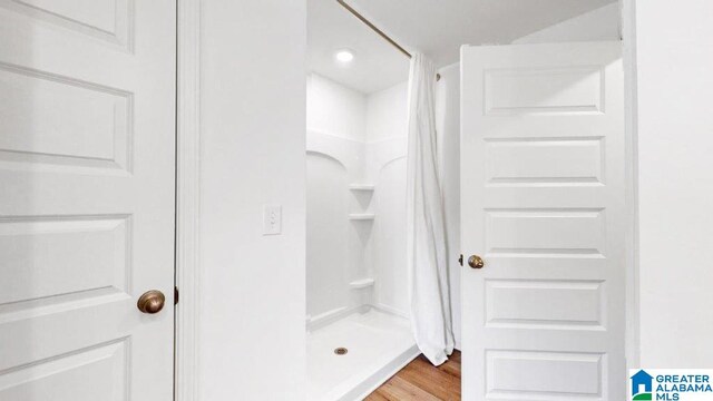 bathroom featuring curtained shower and hardwood / wood-style flooring