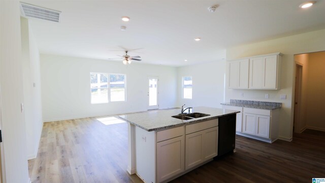 kitchen with white cabinets, sink, hardwood / wood-style flooring, and a kitchen island with sink