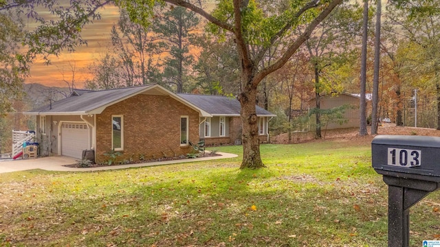 single story home featuring a lawn and a garage