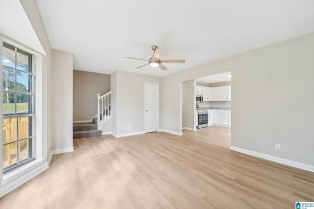 unfurnished living room with light hardwood / wood-style flooring and ceiling fan