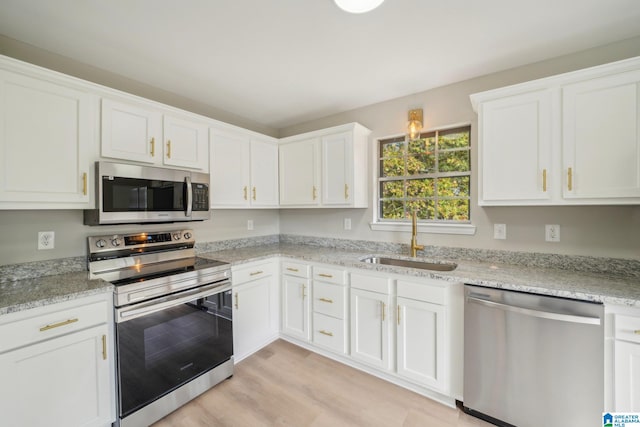 kitchen featuring white cabinets, sink, light hardwood / wood-style floors, and stainless steel appliances