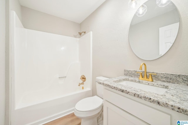 full bathroom featuring hardwood / wood-style floors, shower / washtub combination, toilet, and vanity