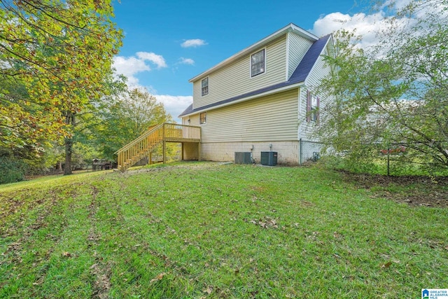 back of house with central AC unit and a lawn