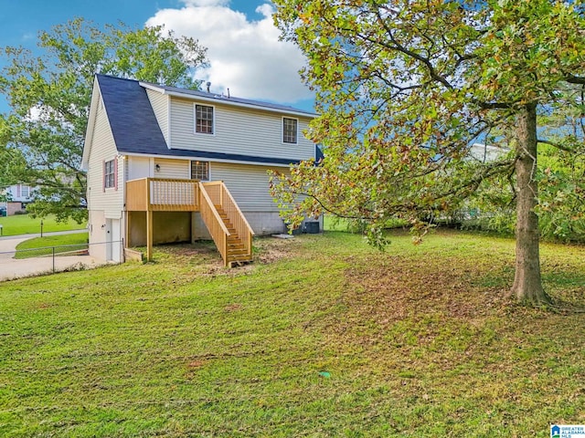 rear view of property featuring central AC unit, a wooden deck, and a lawn