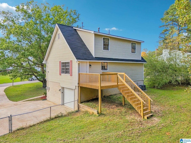 rear view of property with a garage and a lawn