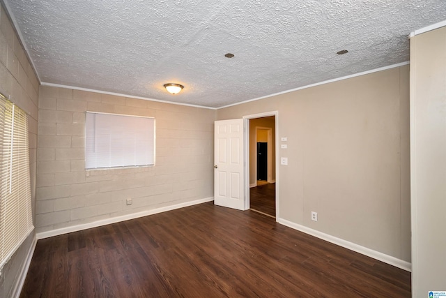 spare room featuring dark hardwood / wood-style floors, a textured ceiling, and ornamental molding