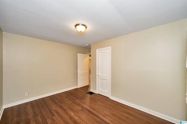 empty room with dark hardwood / wood-style floors